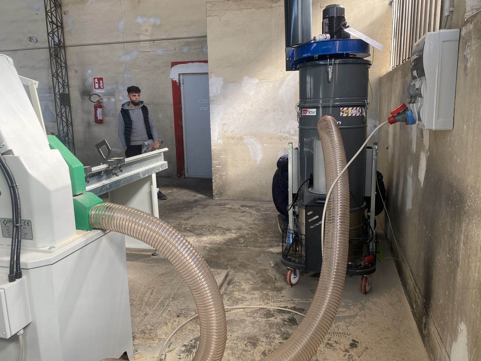 Operatör som arbetar vid såg med anslutet dammutsug