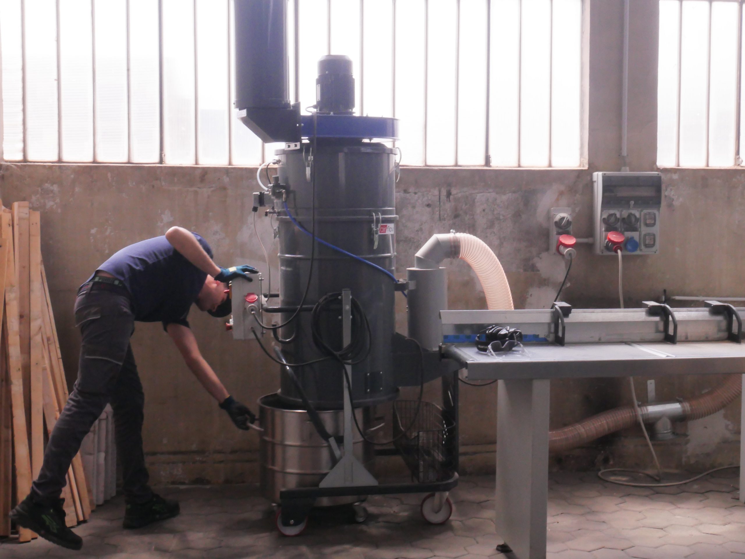 Översiktsbild av snickeriverkstad med dammutsug och maskiner